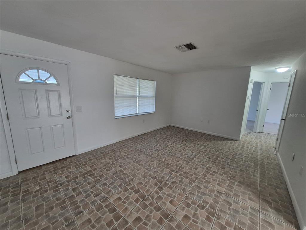 A room with white walls, a front door, a window, and tiled flooring — 9 MICHIGAN STREET, BEVERLY HILLS, FL
