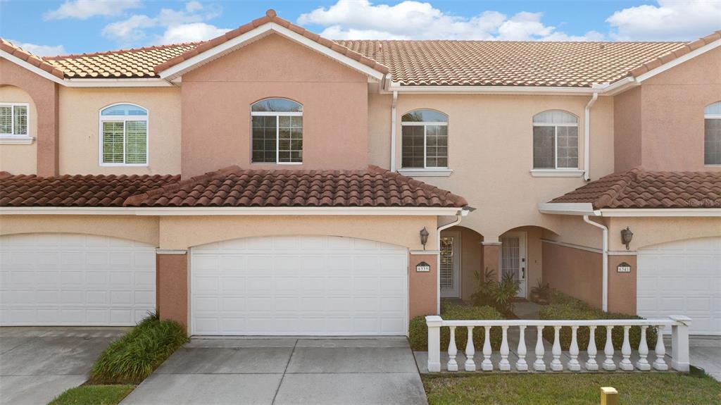 An exterior view of a two-story townhouse with a white garage and tiled roof — 6339 VISTA VERDE DRIVE E, GULFPORT, FL