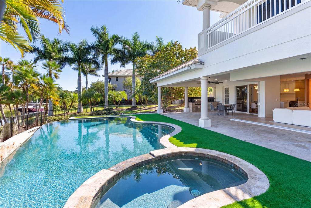 A two-story beige house with a tiled roof, a three-car garage, and a paved driveway — 11007 BIG BASS PLACE, BRADENTON, FL