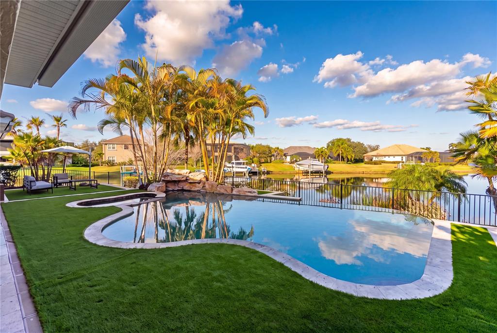 An aerial view shows a two-story house with a tiled roof situated on a canal — 11007 BIG BASS PLACE, BRADENTON, FL