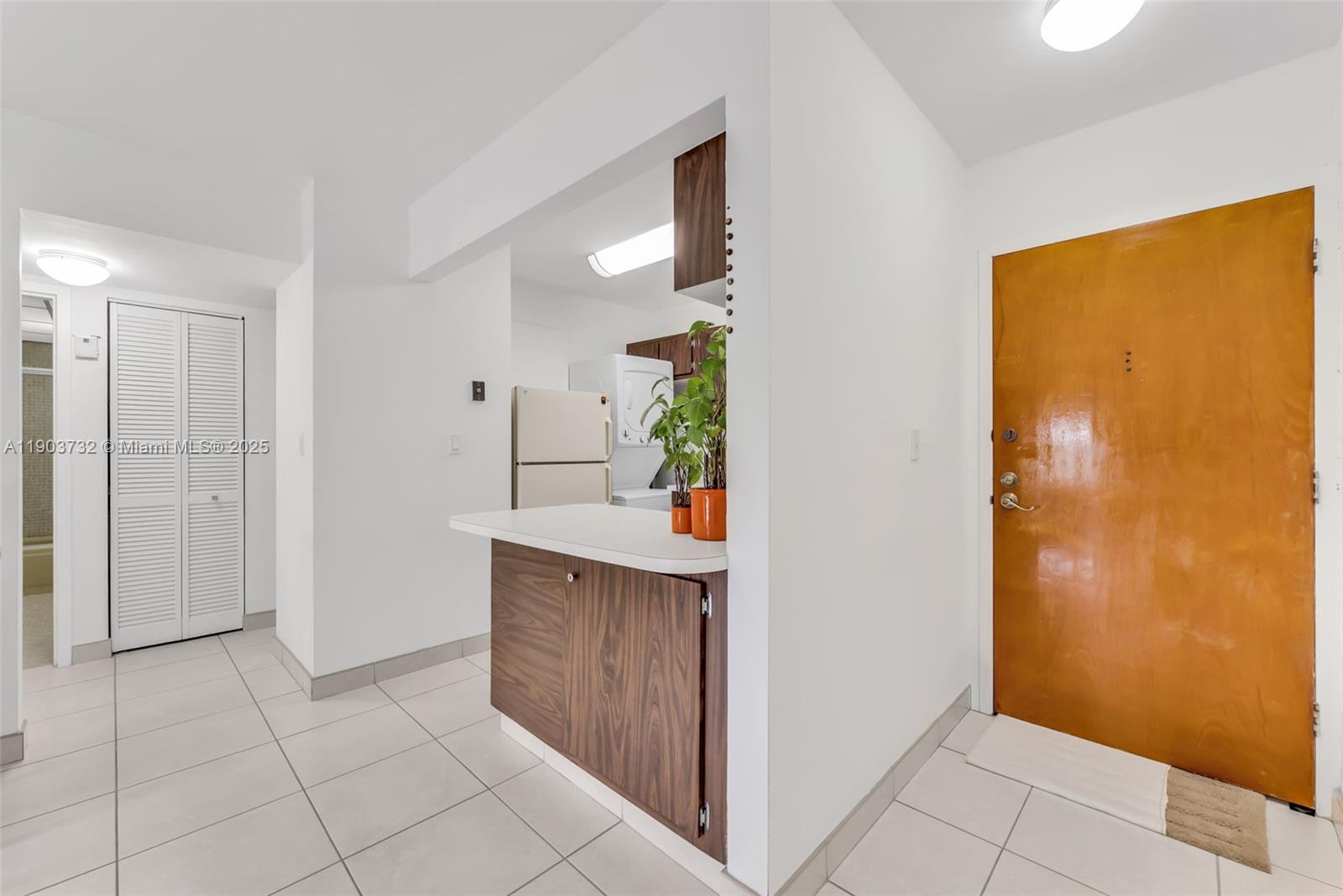 A view of an entryway leading to a kitchen with wood cabinets and white appliances — 3661 SW 9th Ter # 402, Miami FL 33135, MIAMI, FL