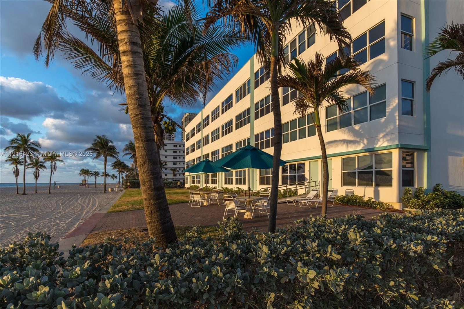 An exterior view of a multi-story building with a patio, palm trees, and beach access — 1801 S Surf Rd # 4, Hollywood FL 33019, HOLLYWOOD, FL