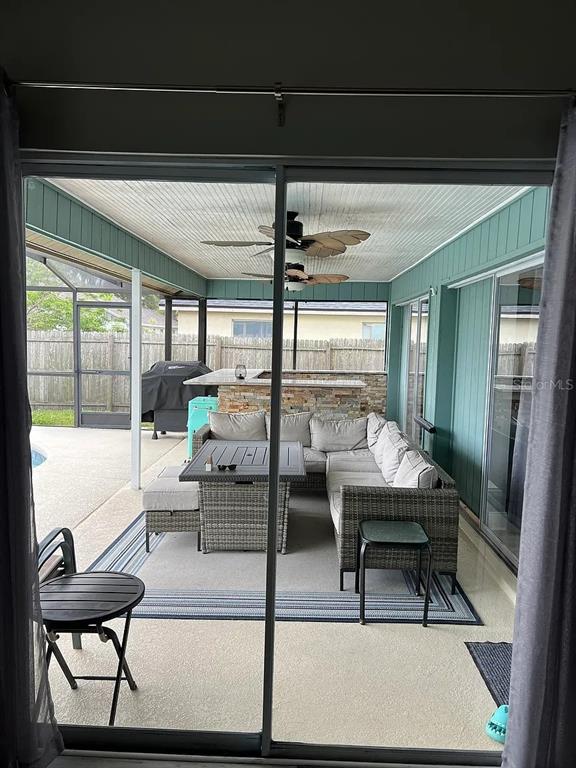 A covered patio features a sectional sofa, dining table, outdoor bar, and ceiling fans — 4314 ELLENVILLE PLACE, VALRICO, FL