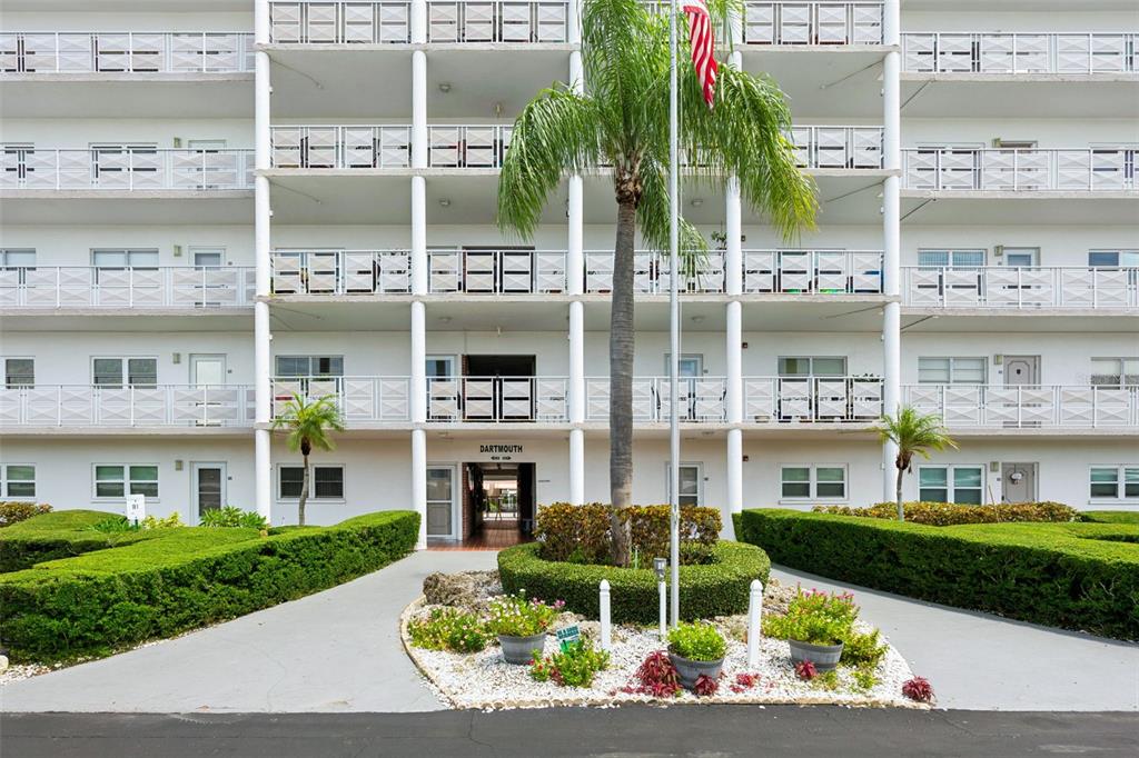 A multi-story white apartment building features a central entrance labeled Dartmouth and a palm tree — 5501 80TH STREET N UNIT 402, ST PETERSBURG, FL