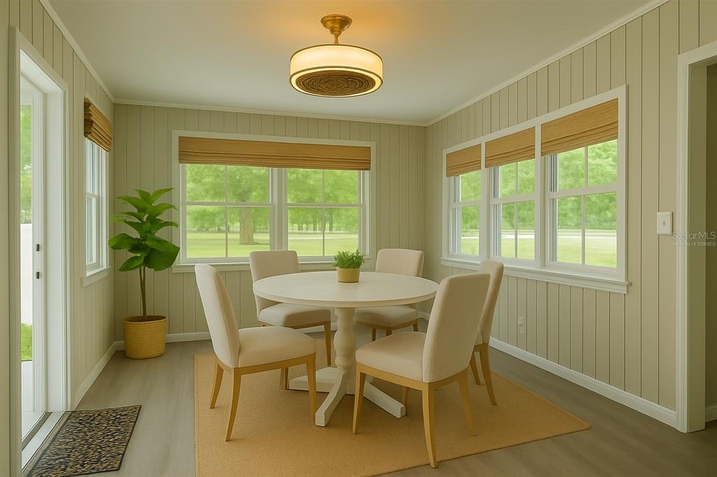 A dining room with light green vertical paneling, a round table, and four chairs — 2722 NANCY STREET, SARASOTA, FL