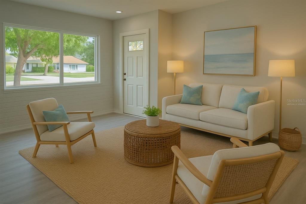 This virtually staged living room features light wood floors, a white sofa, and two armchairs — 2722 NANCY STREET, SARASOTA, FL