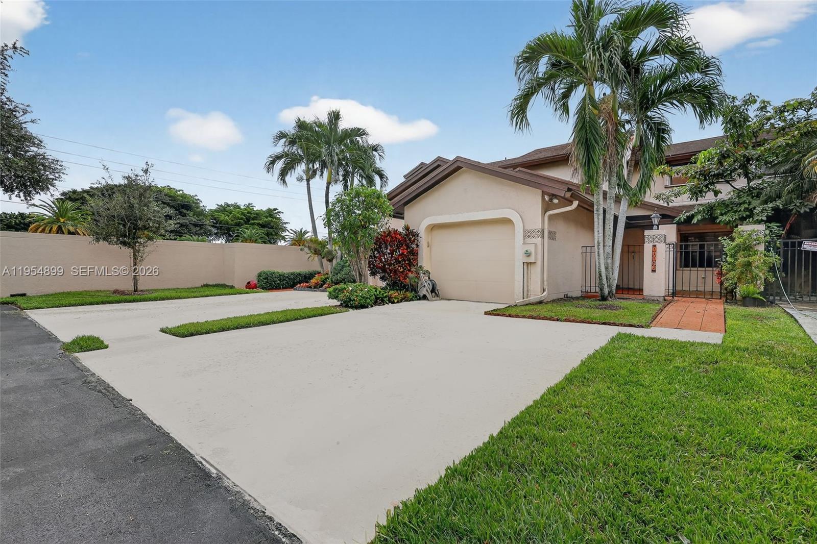 A beige house with a one-car garage, a concrete driveway, and palm trees — 13702 SW 101st Ter, Miami FL 33186, MIAMI, FL