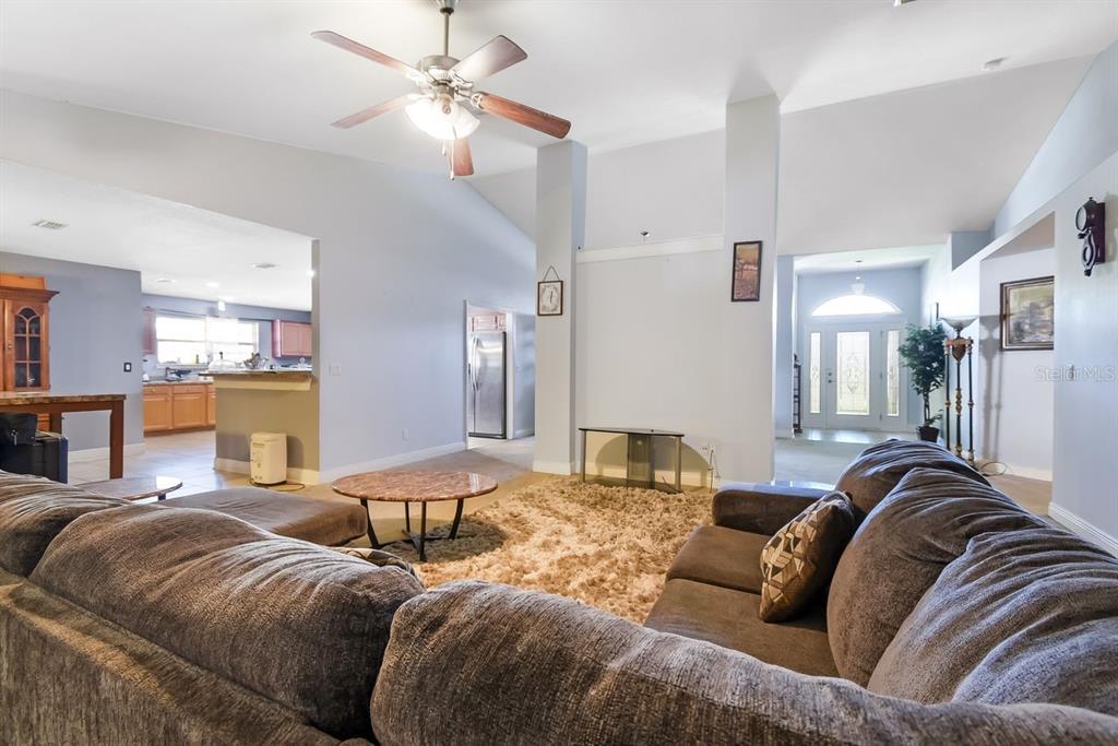 A living room with a large sectional sofa, a shag rug, and a ceiling fan — 46 RIDDLE DRIVE, PALM COAST, FL