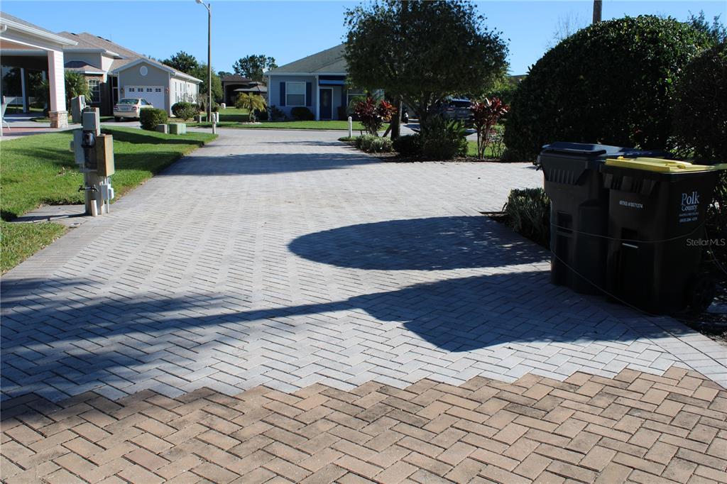 A paved driveway leads toward houses under a clear blue sky — 352 TRAVELERS DRIVE, POLK CITY, FL