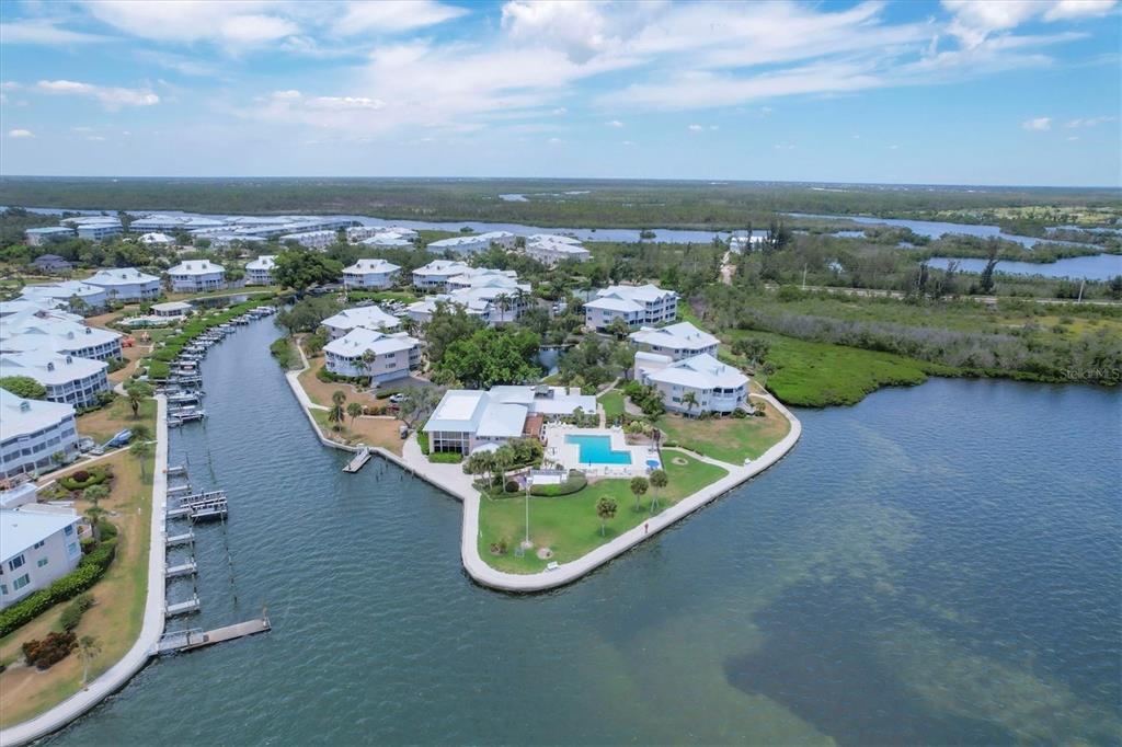An aerial view shows a waterfront residential complex with a pool and boat docks — 11000 PLACIDA ROAD UNIT 101, PLACIDA, FL