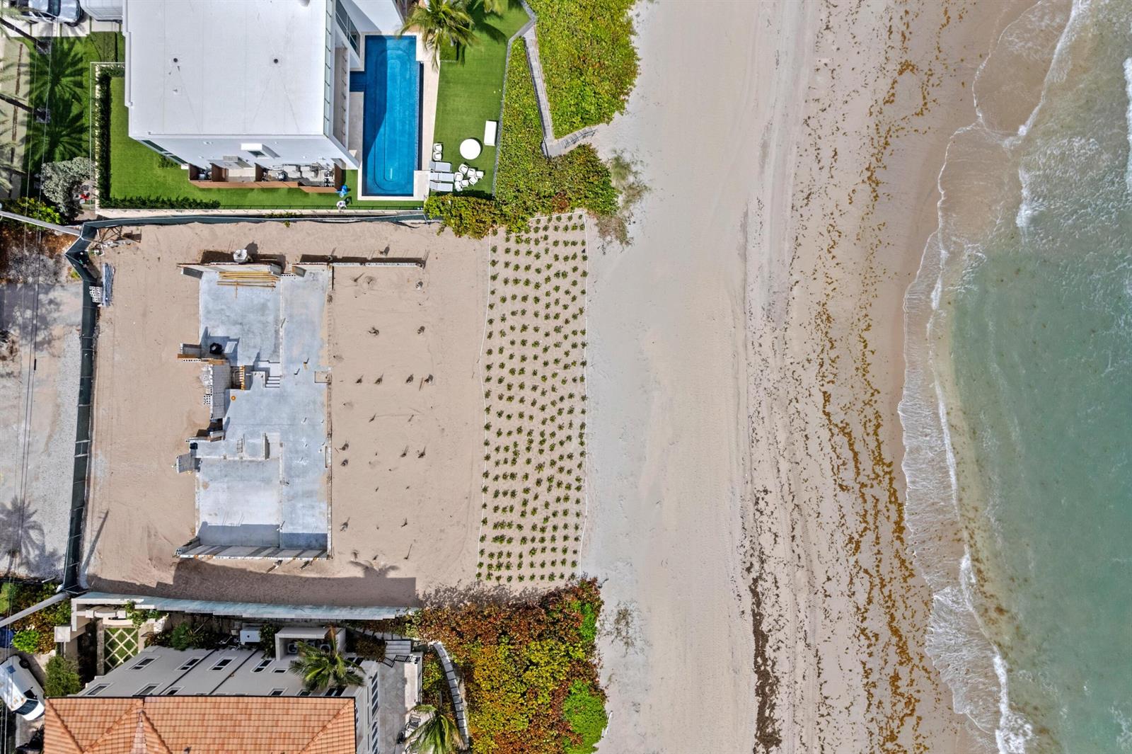 An aerial view shows a beachfront property under construction next to a house with a pool — 3723 S Ocean Boulevard, Highland Beach FL 33487, HIGHLAND BEACH, FL