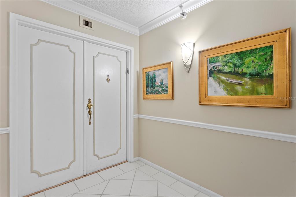 A foyer features white double doors, tiled floors, and two framed landscape paintings on walls — 3301 BAYSHORE BOULEVARD UNIT 1904D, TAMPA, FL