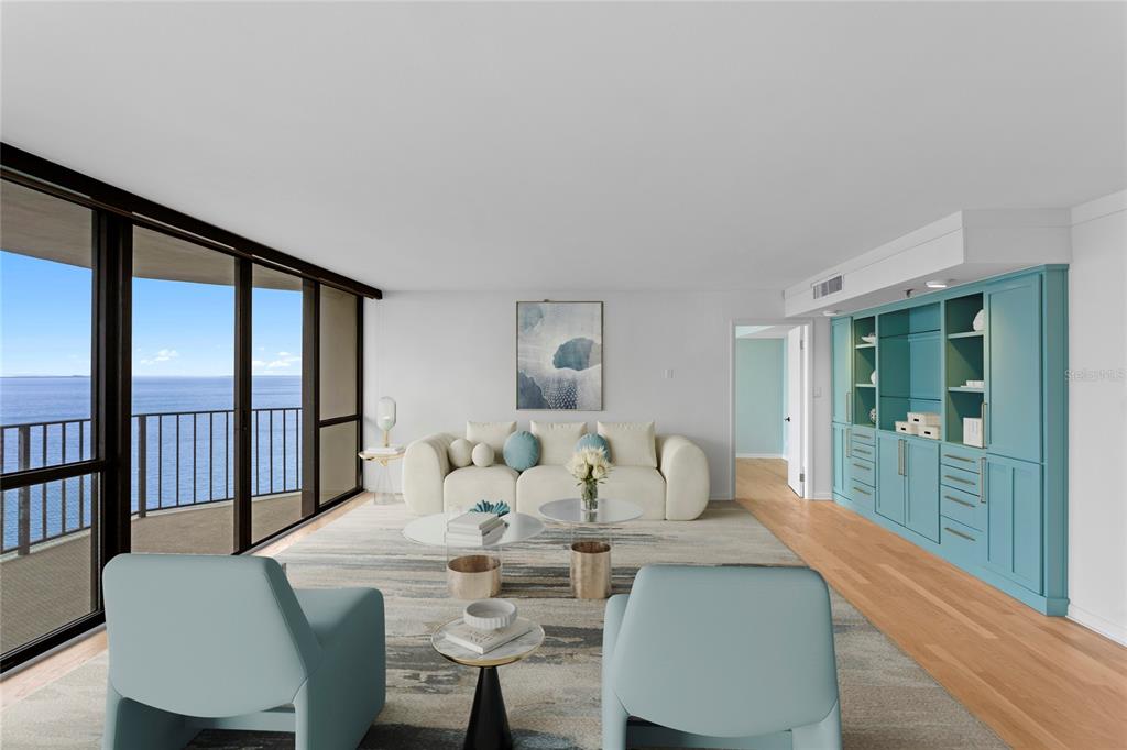 A living room features a white sofa, two light blue chairs, and a teal built-in cabinet — 3301 BAYSHORE BOULEVARD UNIT 1904D, TAMPA, FL