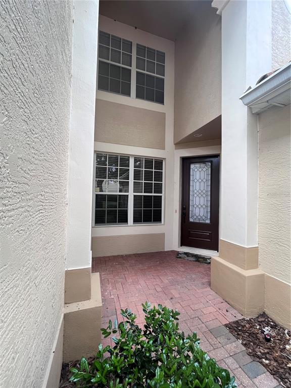 A front entryway features a dark brown door, a brick paver porch, and two-story windows — 8280 VIA VIVALDI, ORLANDO, FL