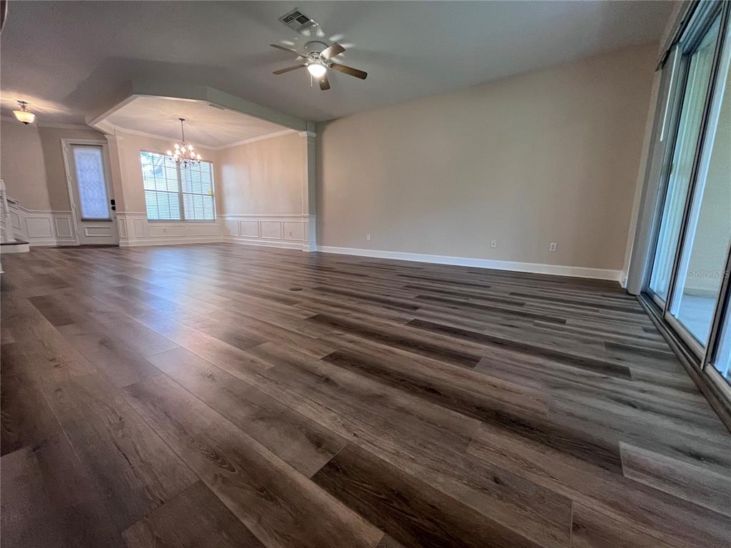 A spacious living area features wood-look flooring, a ceiling fan, and a dining nook — 8280 VIA VIVALDI, ORLANDO, FL