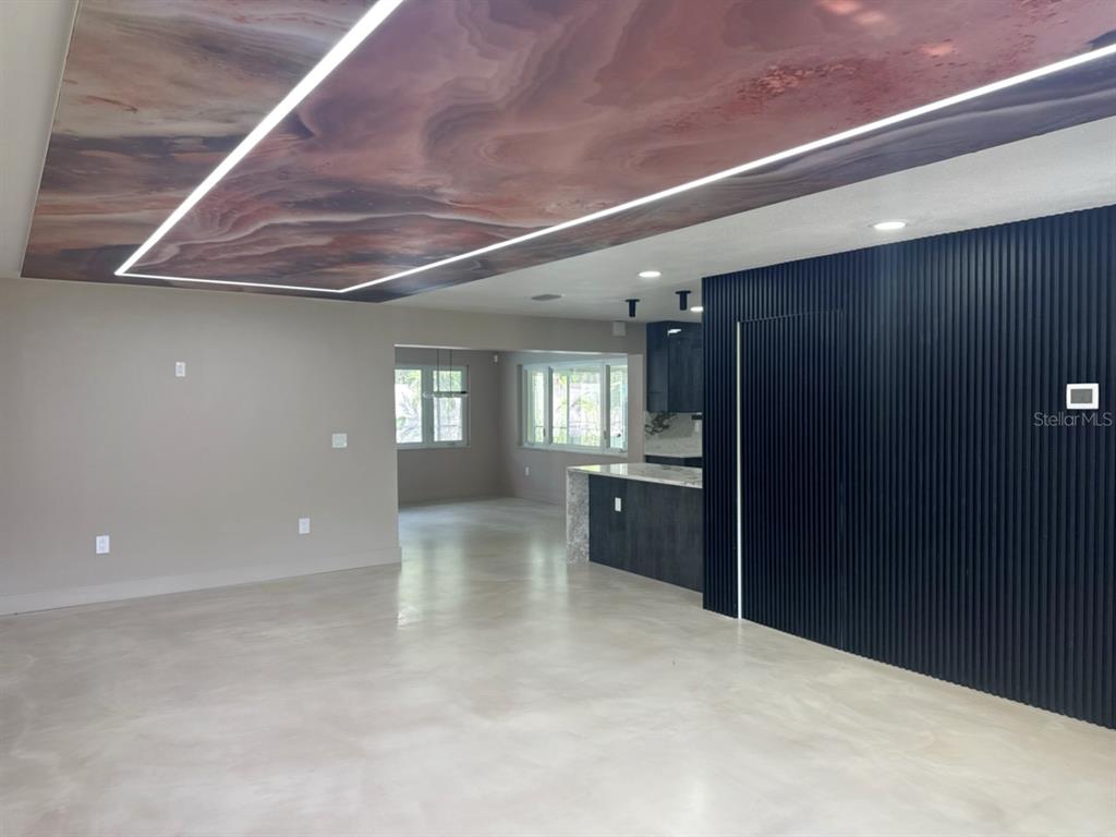 An open-concept living area features a marbled ceiling panel, recessed lighting, and a slatted wall — 3197 WALNUT STREET NE, ST PETERSBURG, FL