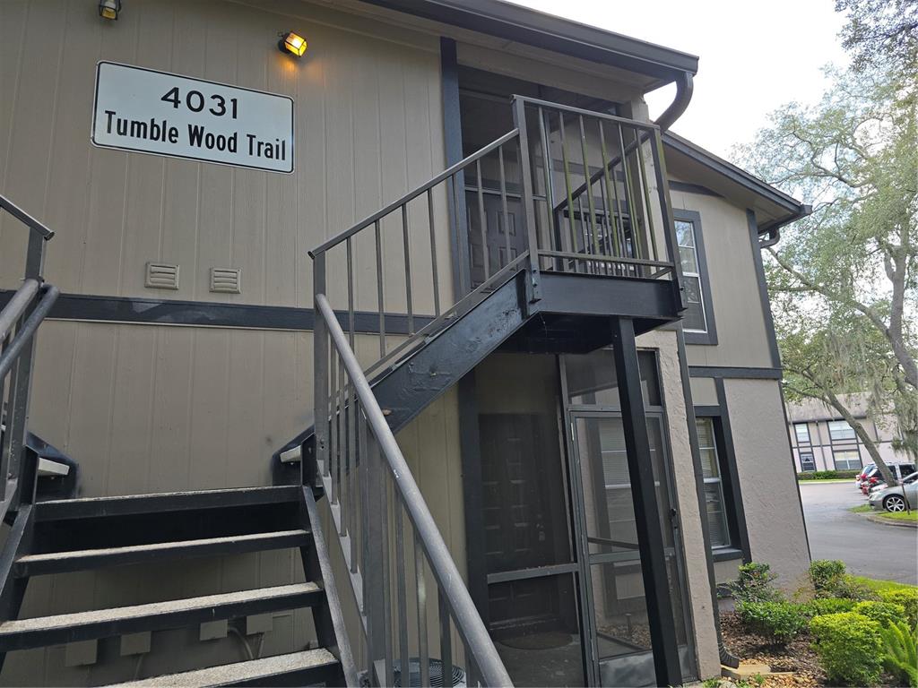 An exterior view of a two-story apartment building with metal stairs leading to the second floor — 4031 TUMBLE WOOD TRAIL UNIT 203, TAMPA, FL