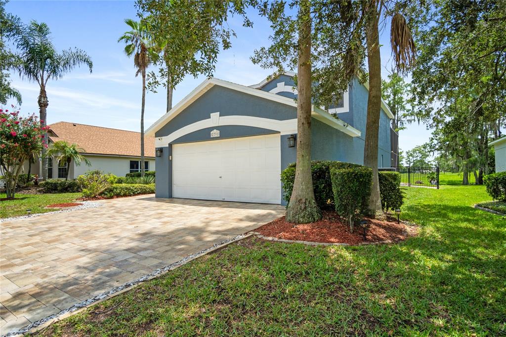 A blue two-story house features a white garage door and a paved driveway — 2791 RUNYON CIRCLE, ORLANDO, FL