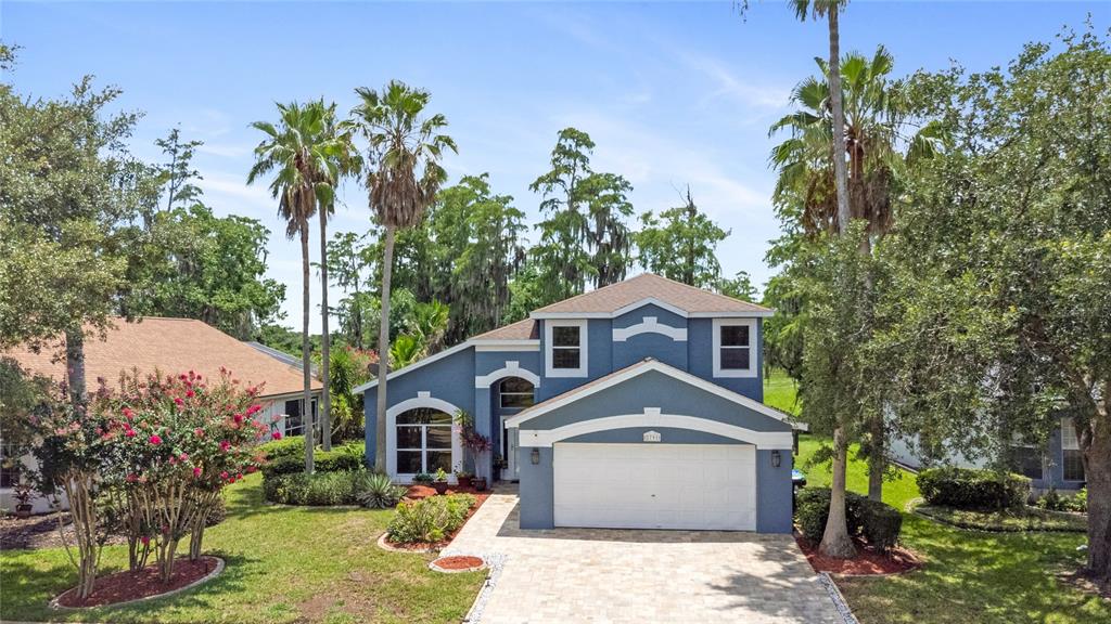 A blue two-story house with a white garage and palm trees in the front yard — 2791 RUNYON CIRCLE, ORLANDO, FL