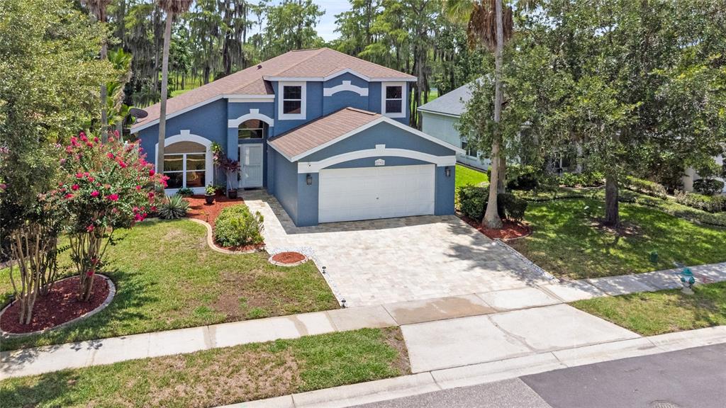 An aerial view of a blue two-story house with a paved driveway and front lawn — 2791 RUNYON CIRCLE, ORLANDO, FL