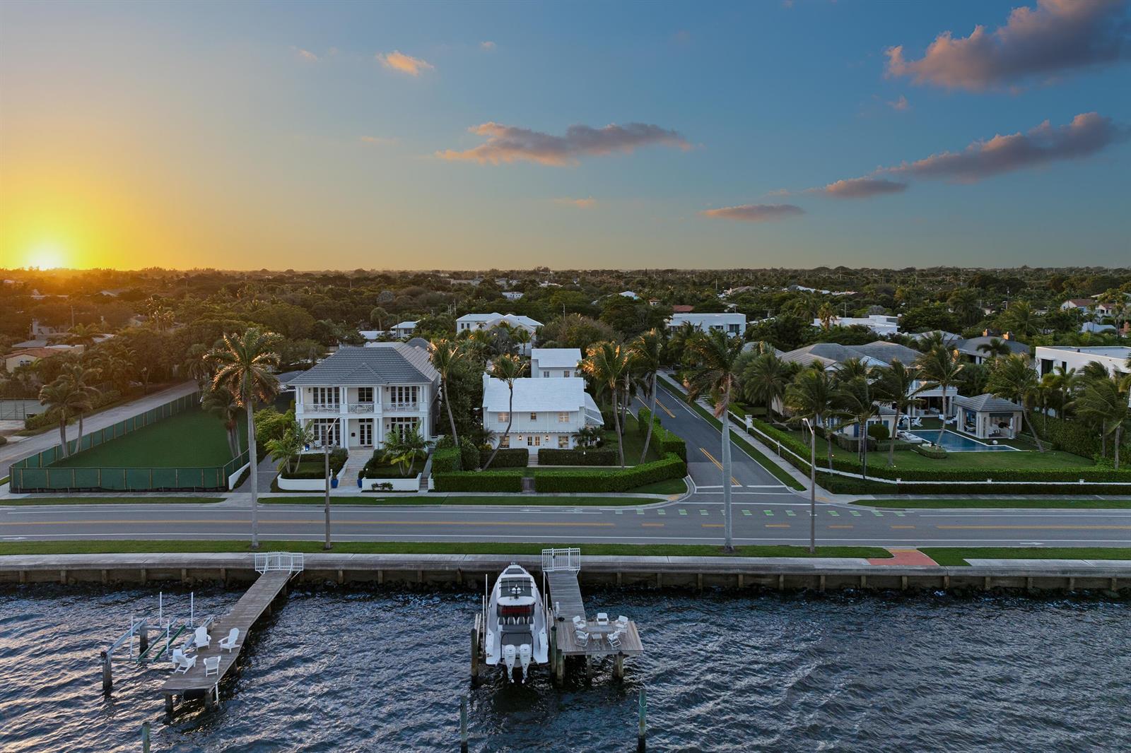 An aerial view shows a waterfront home with a private dock and boat at sunset — 7103 S Flagler Drive, West Palm Beach FL 33405, WEST PALM BEACH, FL