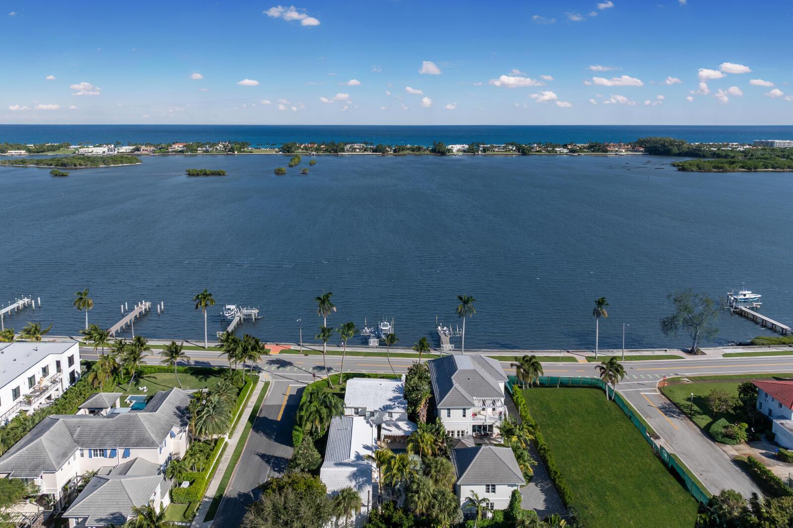 An aerial view shows waterfront homes, a road, docks, and a large body of water — 7103 S Flagler Drive, West Palm Beach FL 33405, WEST PALM BEACH, FL