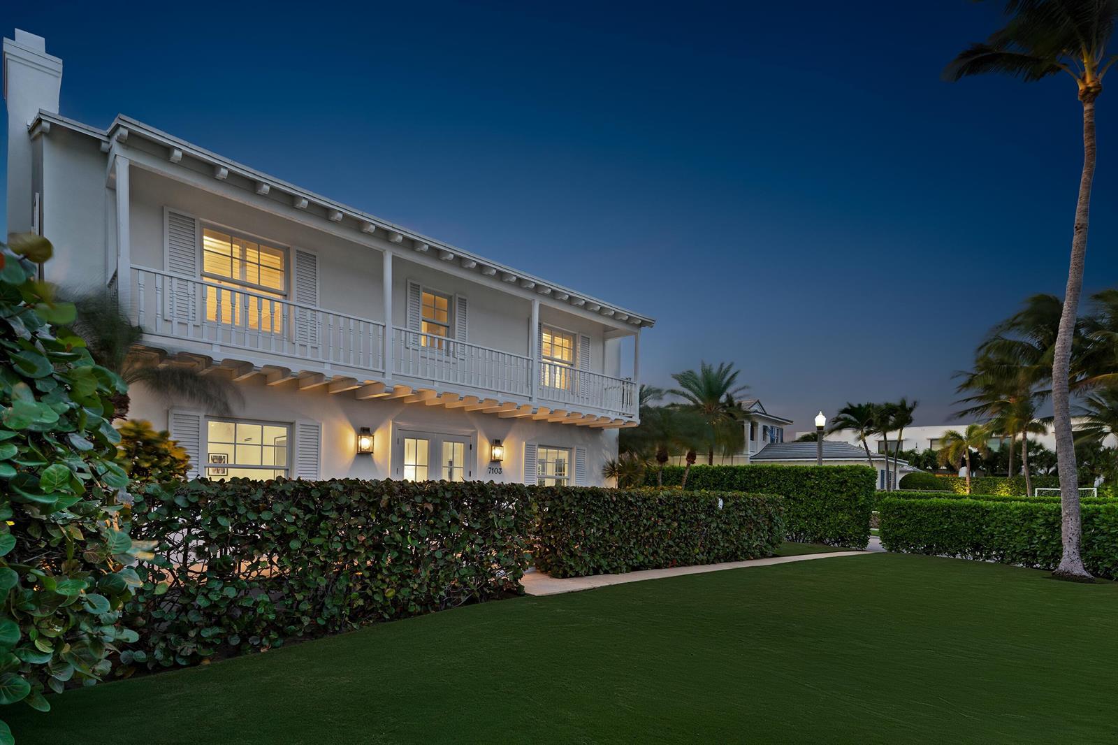A two-story white house with a balcony and hedge-lined lawn at twilight — 7103 S Flagler Drive, West Palm Beach FL 33405, WEST PALM BEACH, FL