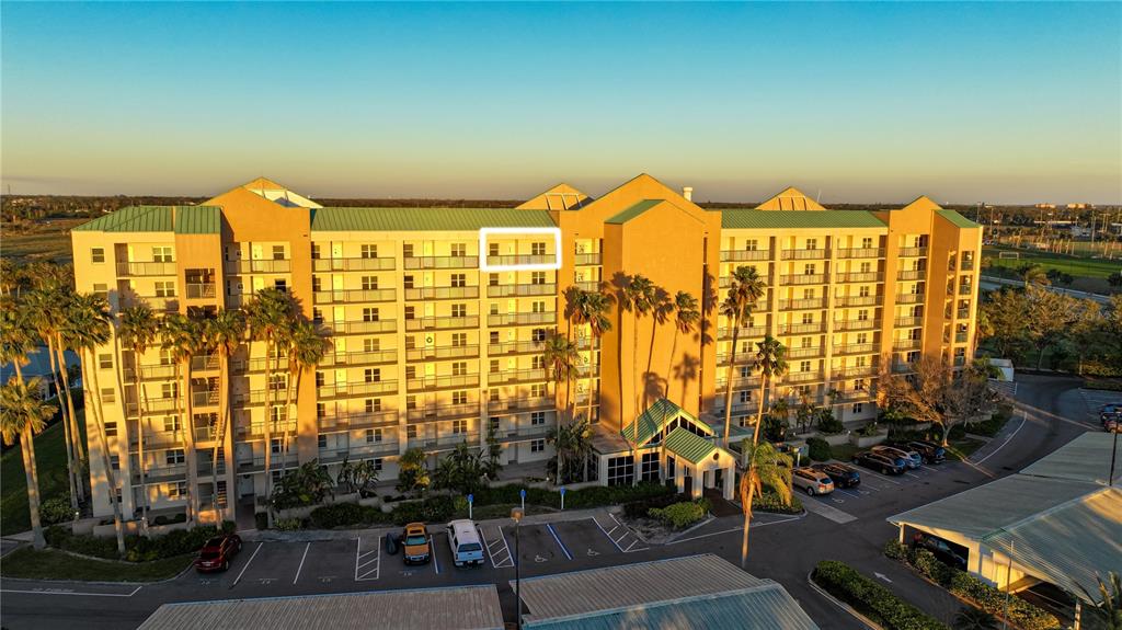 An exterior view of a multi-story apartment building with a green roof and palm trees — 2320 TERRA CEIA BAY BOULEVARD UNIT 706, PALMETTO, FL