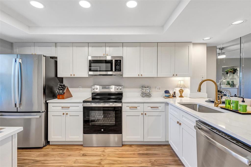 A kitchen with white cabinets, stainless steel appliances, and wood-look flooring — 2320 TERRA CEIA BAY BOULEVARD UNIT 706, PALMETTO, FL