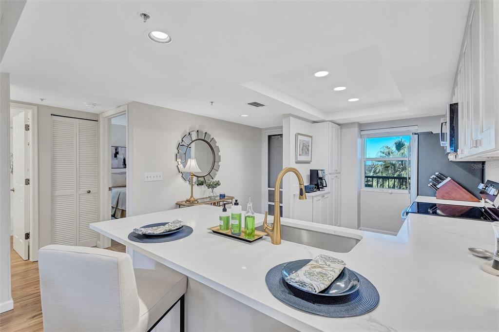 A modern kitchen features a white quartz island with a gold faucet and bar seating — 2320 TERRA CEIA BAY BOULEVARD UNIT 706, PALMETTO, FL