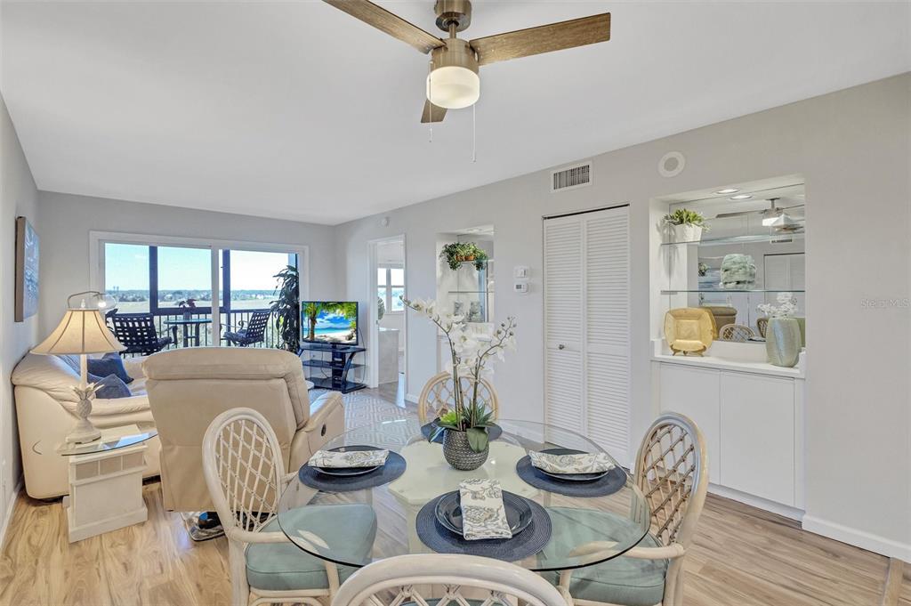 A dining area with a glass table and wicker chairs opens into a living room — 2320 TERRA CEIA BAY BOULEVARD UNIT 706, PALMETTO, FL