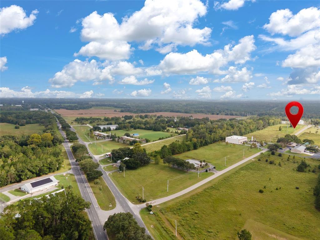 An aerial view shows a rural landscape with roads, scattered buildings, and a red location pin — 13157 NW 104TH TERRACE, ALACHUA, FL