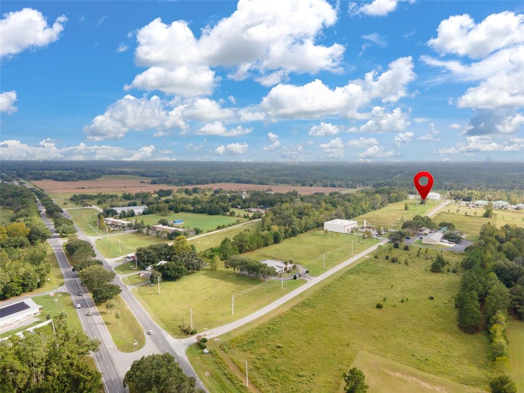 An aerial view shows a rural landscape with a red location pin over a building — 13157 NW 104TH TERRACE, ALACHUA, FL
