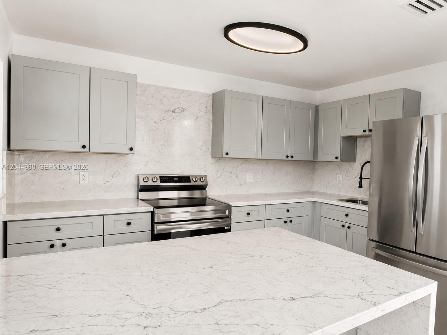 A kitchen features gray cabinets, white marble-patterned countertops, and stainless steel appliances — 3435 SW 91st Ave # 0, Miami FL 33165, MIAMI, FL