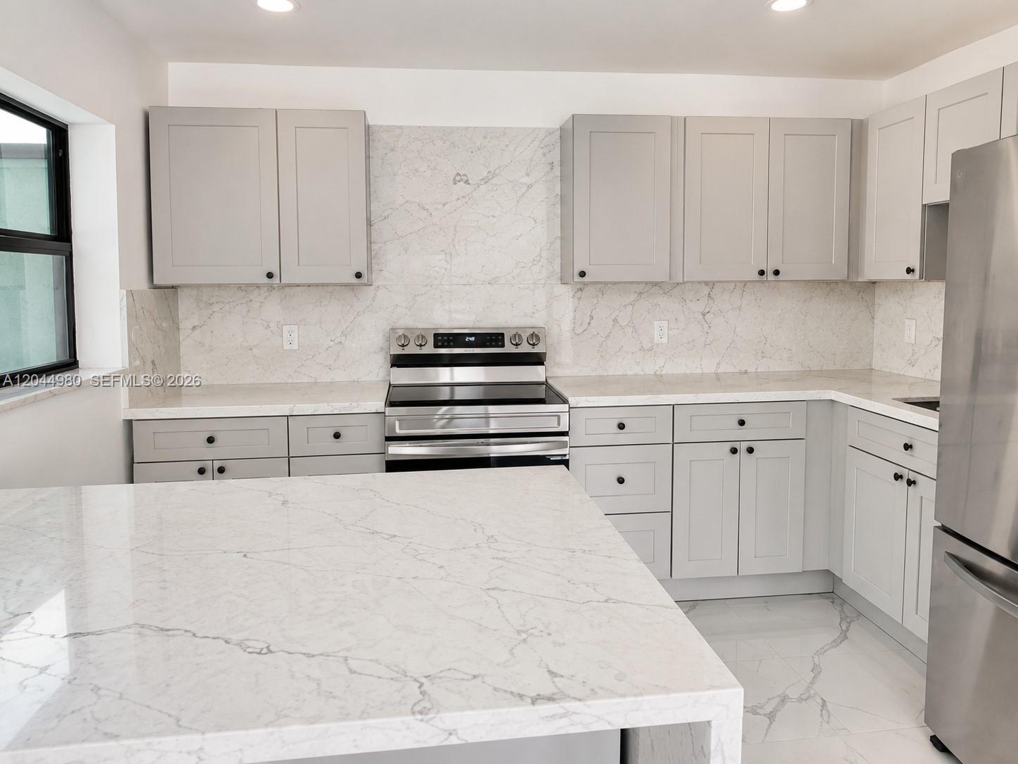 A modern kitchen features light gray cabinets, white marble countertops, and stainless steel appliances — 3435 SW 91st Ave # 0, Miami FL 33165, MIAMI, FL