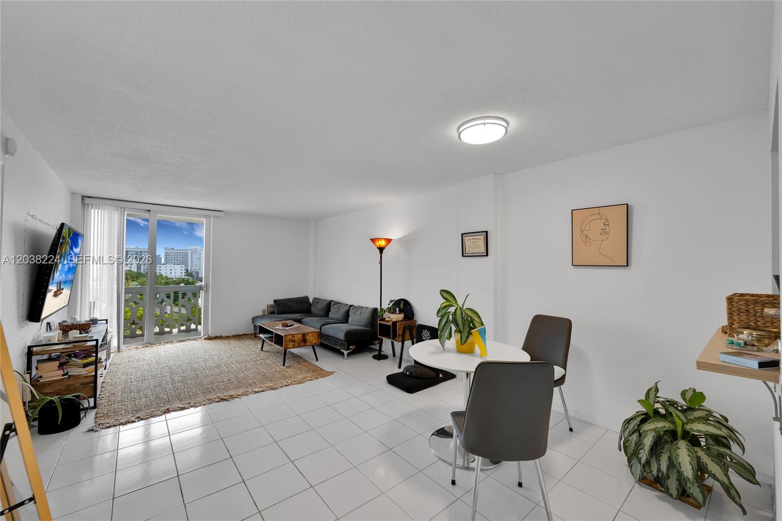 A living and dining area features white tile floors, a sectional sofa, and a balcony — 1020 Meridian Ave # 715, Miami Beach FL 33139, MIAMI BEACH, FL