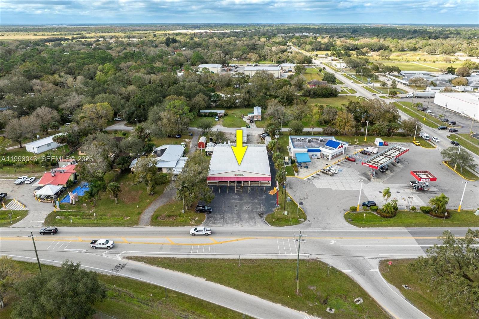 An aerial view shows a commercial building with a yellow arrow pointing to its roof — 1060 SR 29 S, La Belle FL 33935, LA BELLE, FL