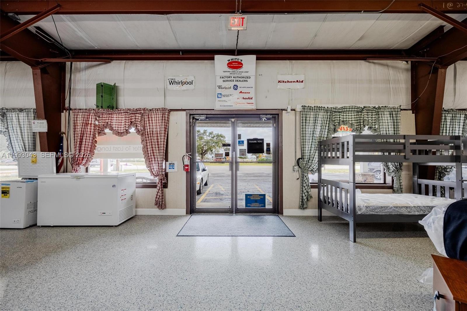 A retail showroom features a glass entrance door, chest freezers, and a bunk bed — 1060 SR 29 S, La Belle FL 33935, LA BELLE, FL