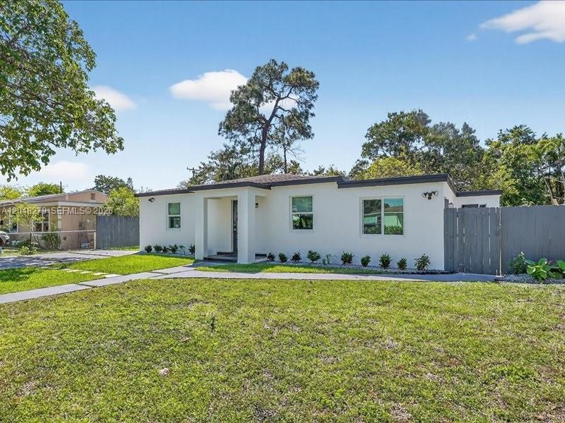 A single-story white house with a flat roof and a gray wooden fence — 1010 NE 138th St, North Miami FL 33161, NORTH MIAMI, FL