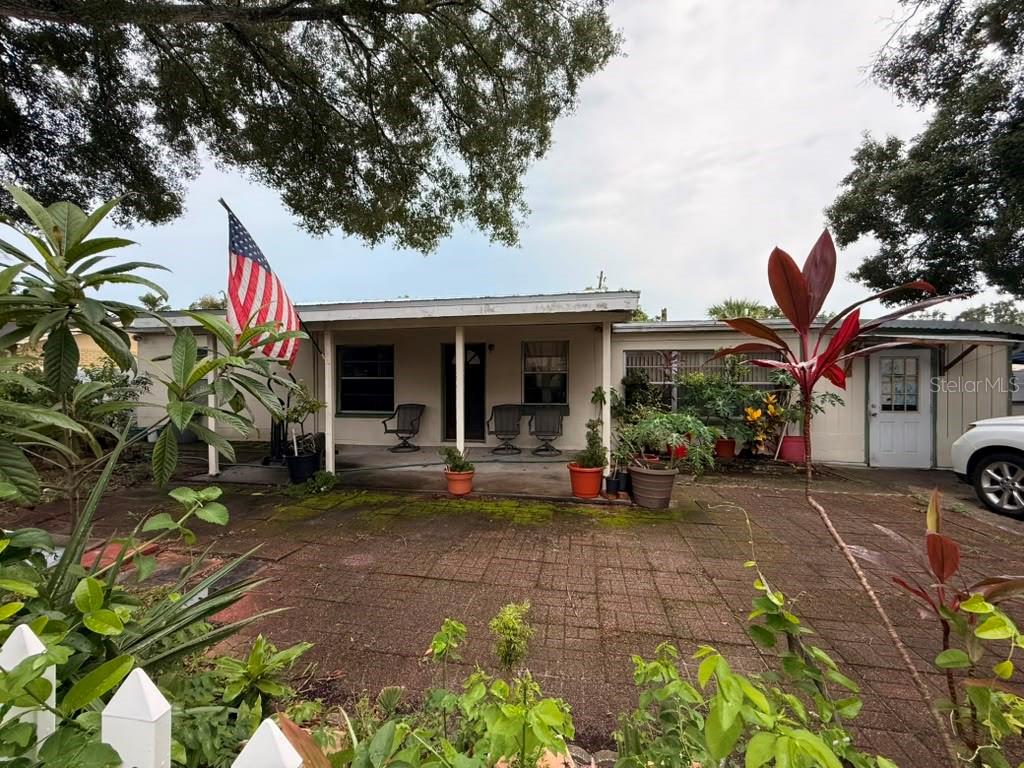 A single-story house with a covered front porch, brick paver patio, and an American flag — 4203 S TRASK STREET, TAMPA, FL