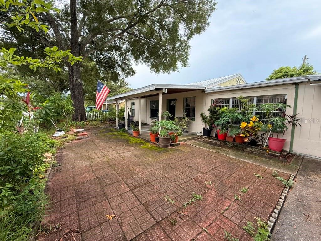 A paved patio sits in front of a single-story house with a covered porch — 4203 S TRASK STREET, TAMPA, FL