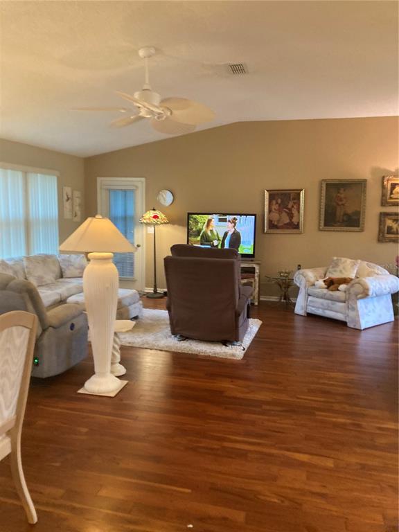A living room features hardwood floors, a ceiling fan, and a television on a stand — 8744 SW 108TH LANE ROAD, OCALA, FL