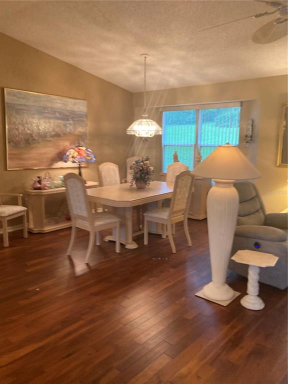 A dining area features a wooden table, four chairs, a pendant light, and hardwood floors — 8744 SW 108TH LANE ROAD, OCALA, FL