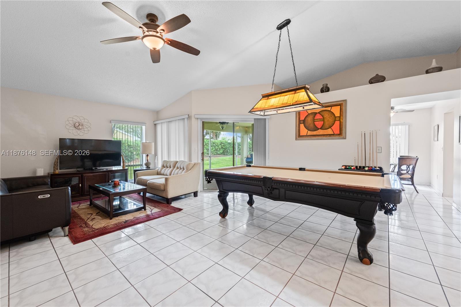 A living room features a pool table, tile flooring, a ceiling fan, and sliding doors — 2585 SE 7th Pl, Homestead FL 33033, HOMESTEAD, FL