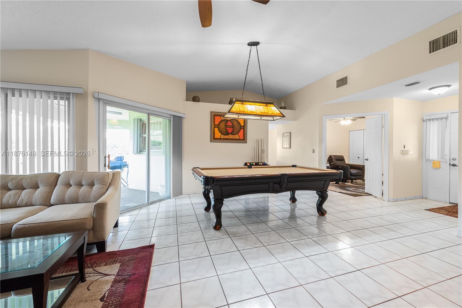 A room with white tile floors features a pool table and a hanging light fixture — 2585 SE 7th Pl, Homestead FL 33033, HOMESTEAD, FL