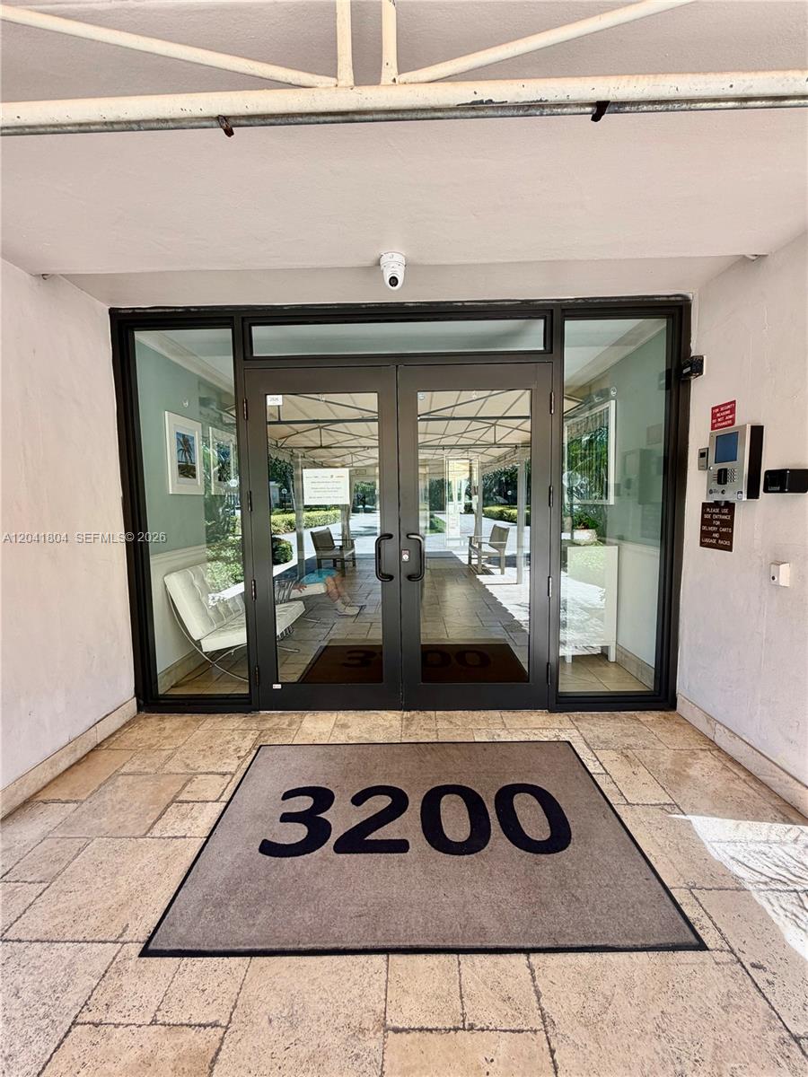 A glass double door entrance features a floor mat labeled 3200 and a security camera — 3200 N Palm Aire Dr # 710, Pompano Beach FL 33069, POMPANO BEACH, FL