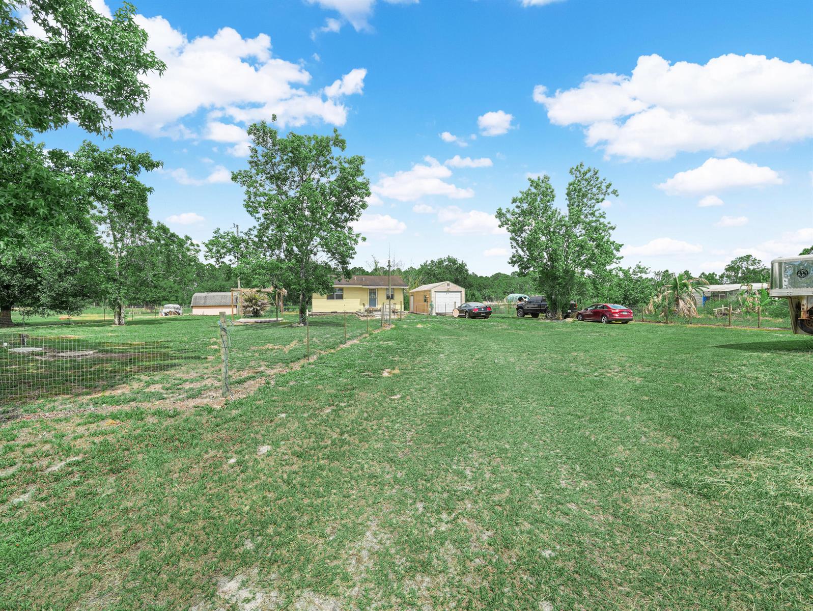 A yellow house sits on a large grassy lot with trees and several outbuildings — 4002 Everhigh Acres Road, Clewiston FL 33440, CLEWISTON, FL