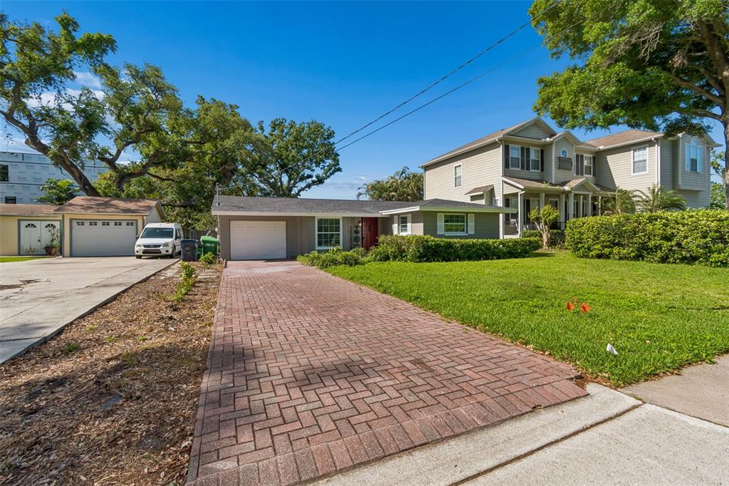 A single-story house with a brick driveway and a two-story house next door — 4906 W CLEVELAND STREET, TAMPA, FL