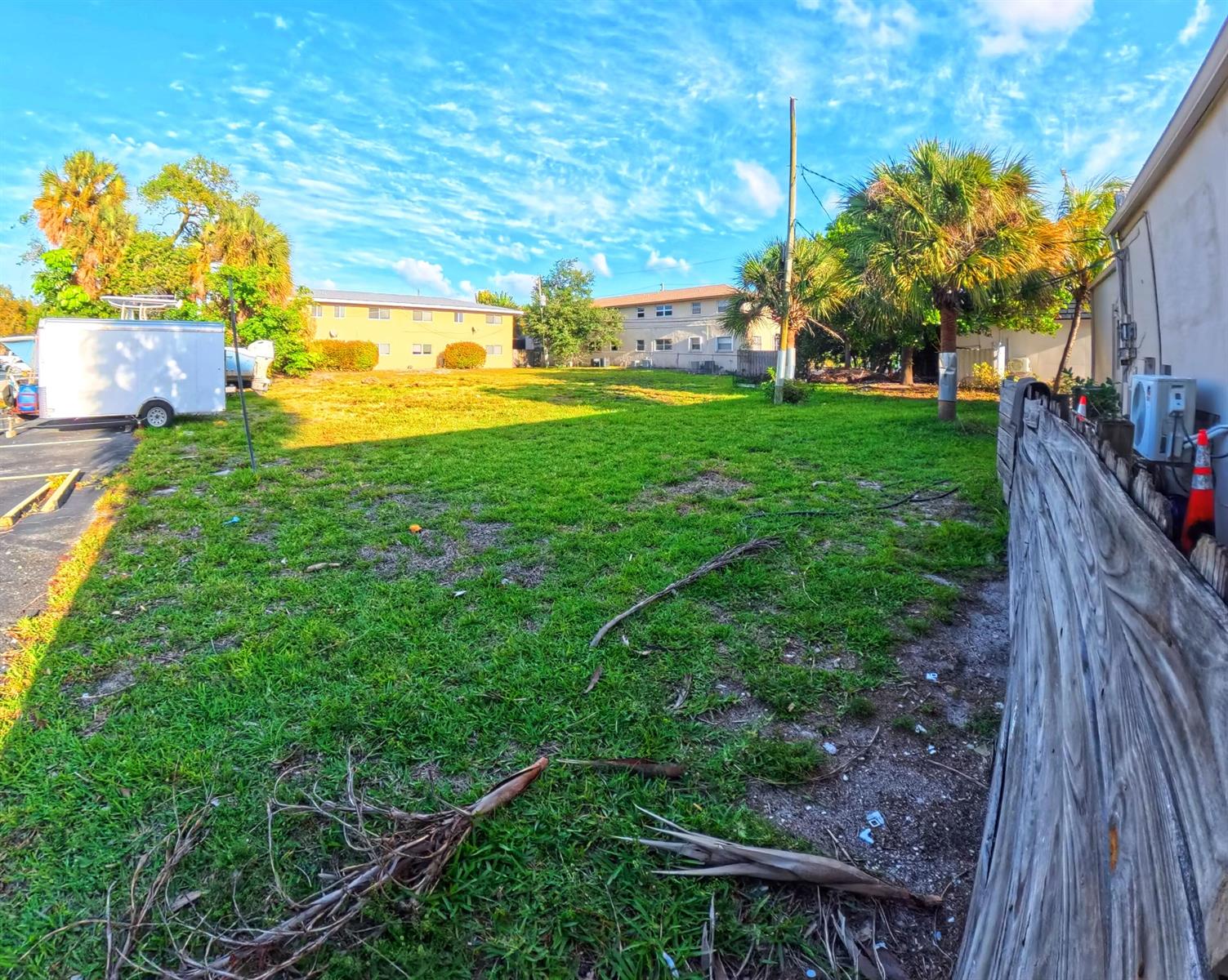 A grassy vacant lot sits between a wooden fence and a white trailer — 520-580 S Federal Highway, Pompano Beach FL 33062, POMPANO BEACH, FL