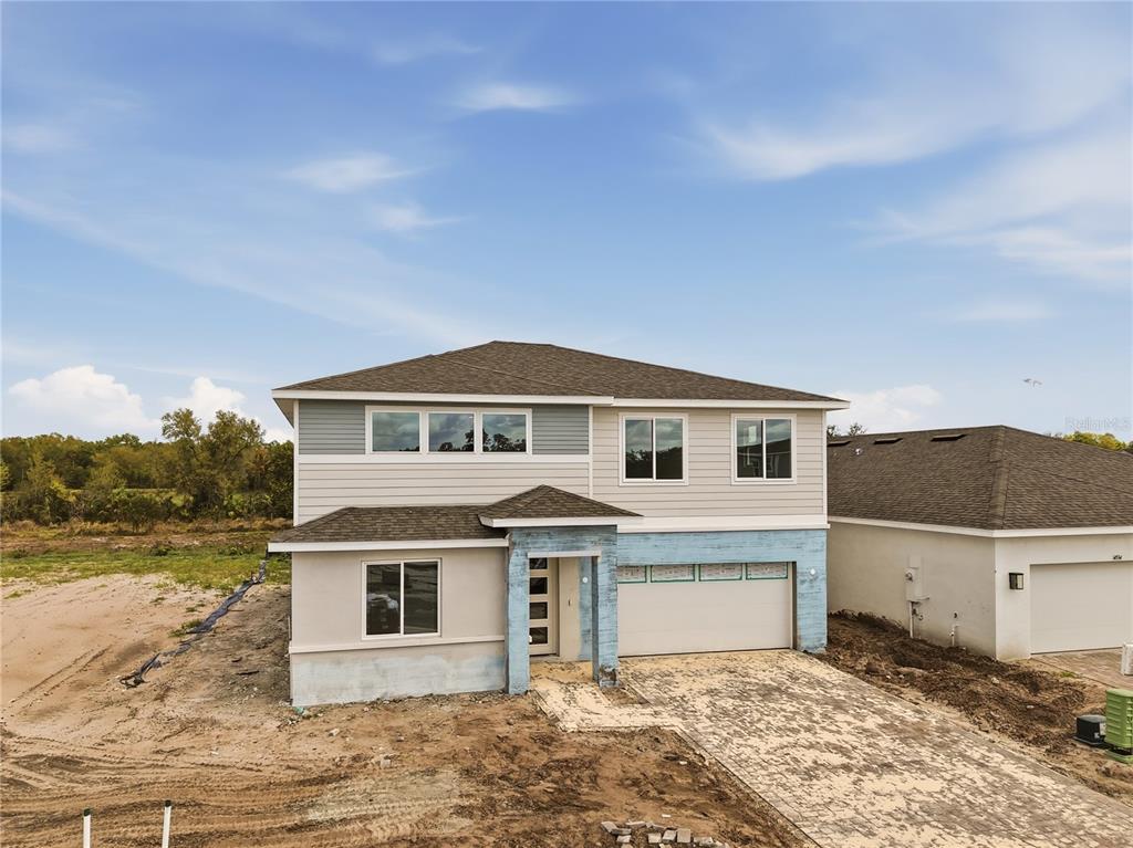 A two-story house with a light-colored exterior, stone accents, and an attached two-car garage — 14530 BANKS COURT, PARRISH, FL